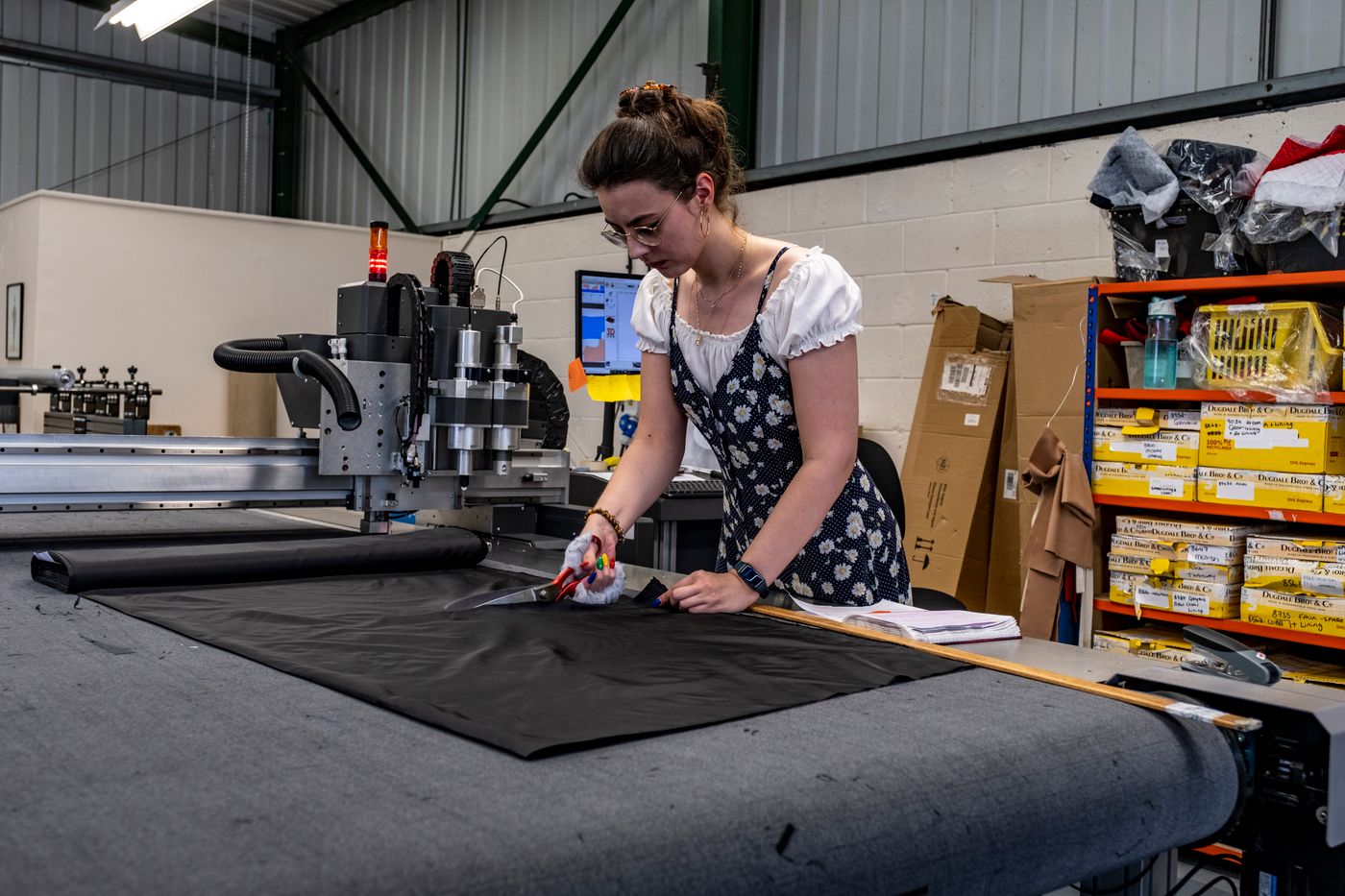 Industry reference: a worker cutting fabric, not the AAS factory